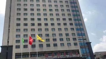 A tall building with multiple windows and flags.