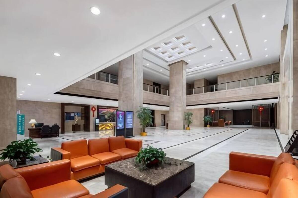 A spacious lobby with a high ceiling, multiple seating areas, and a reception desk.