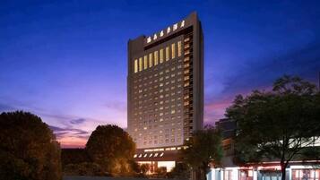 A multi-story hotel with a modern facade, large windows, and a well-lit entrance.