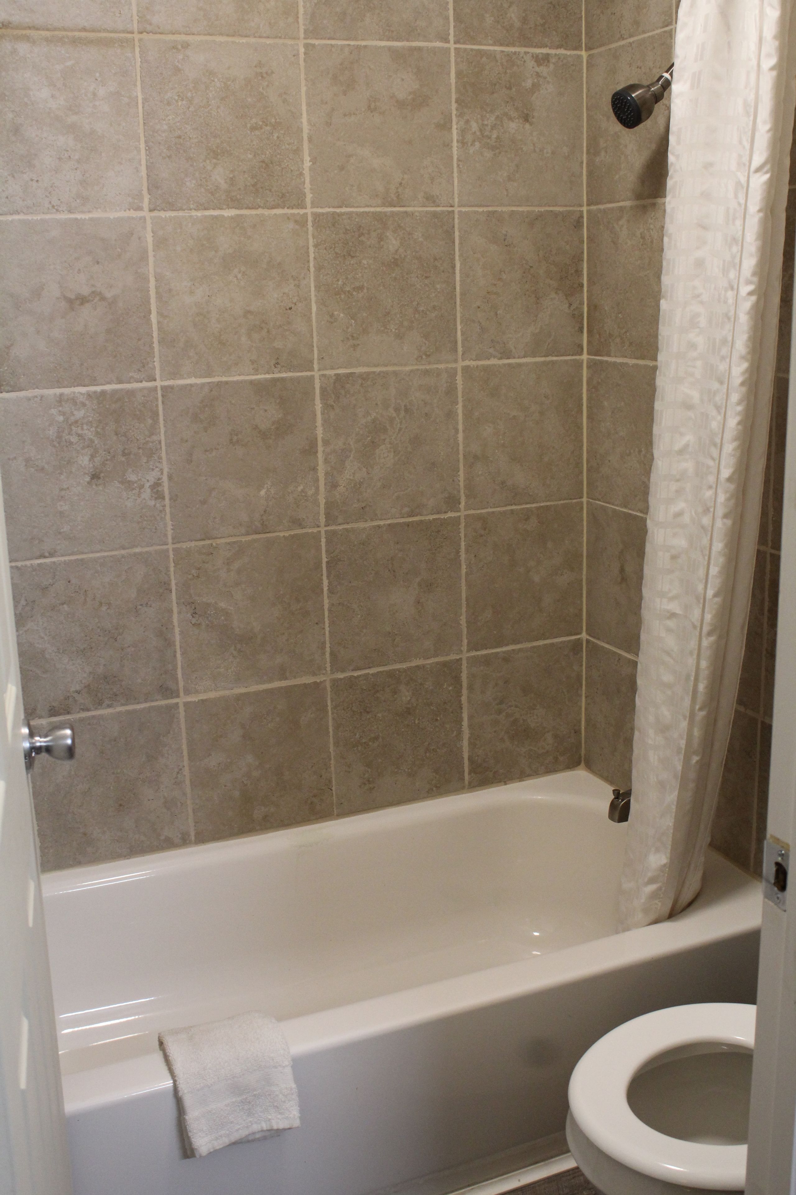 Une salle de bain avec une baignoire, des toilettes et un rideau de douche.