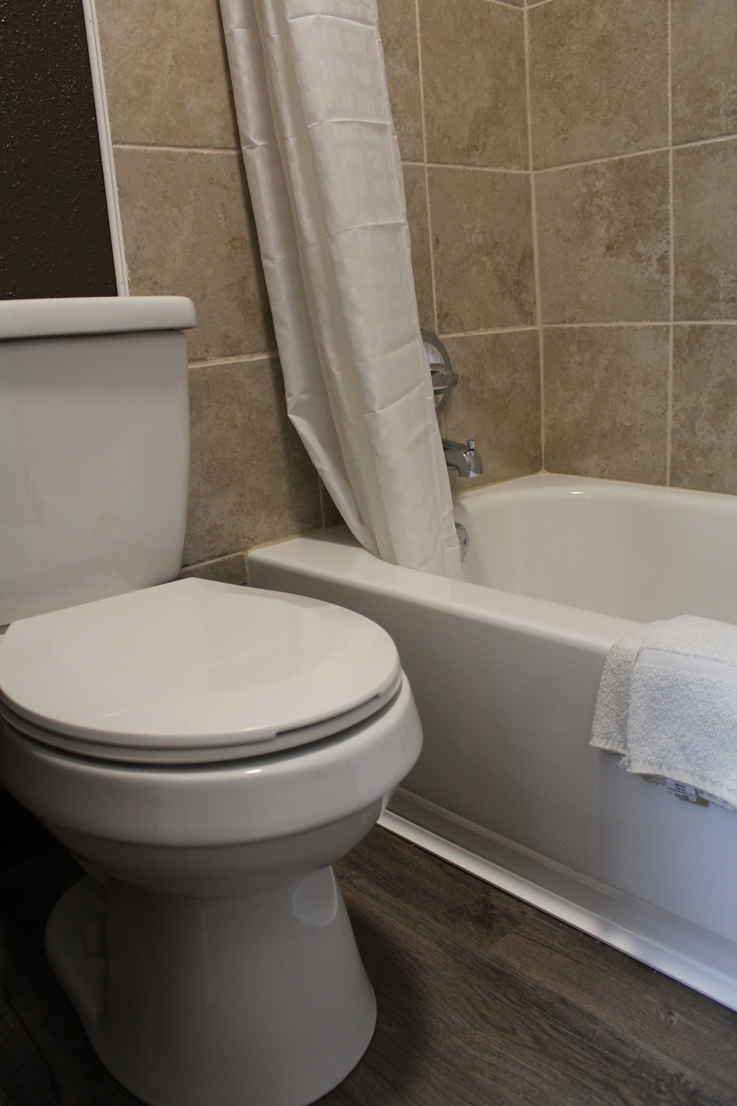 Un baño con inodoro, bañera y cortina de ducha.