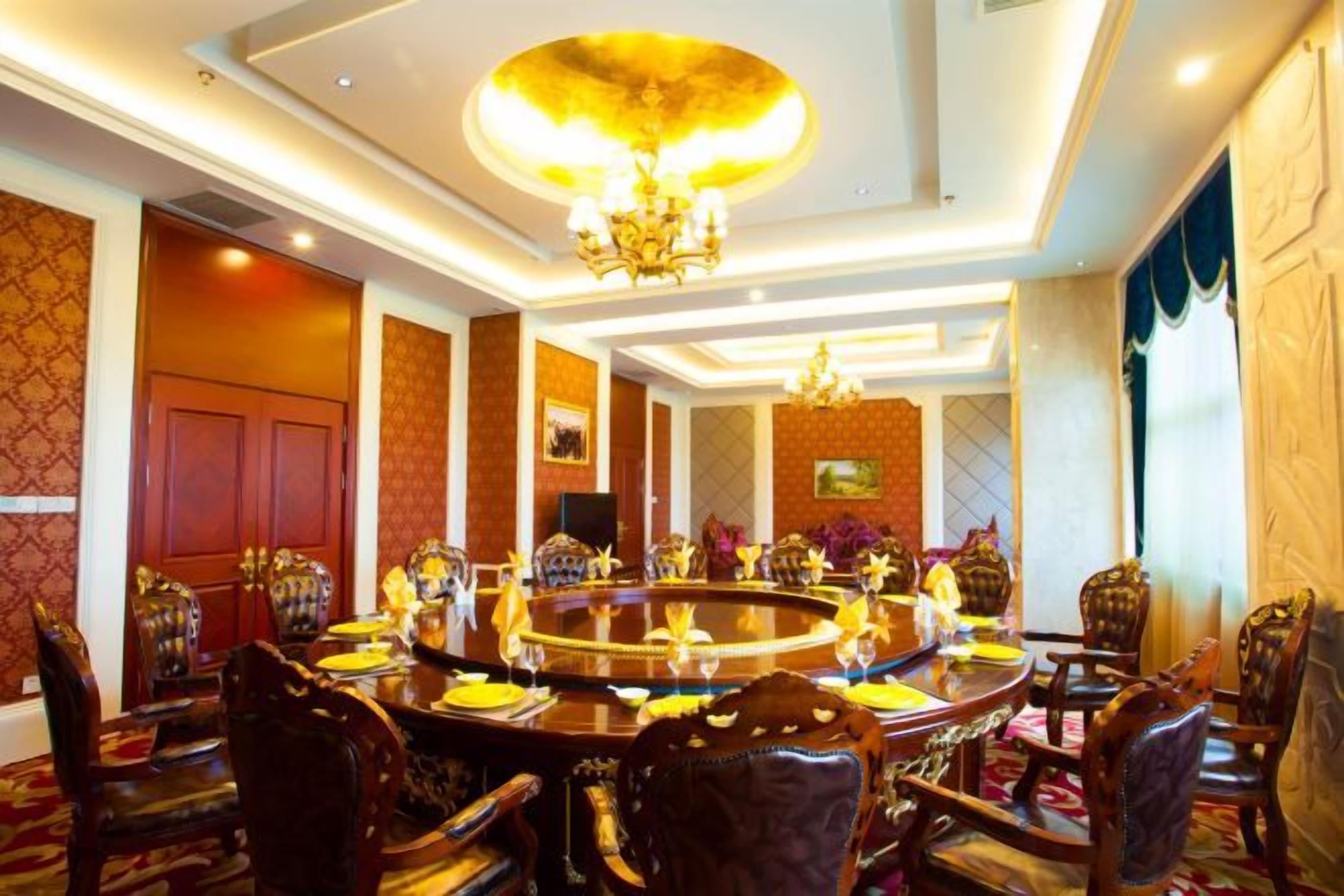 A formal dining room with a round table, ornate chairs, and a chandelier.