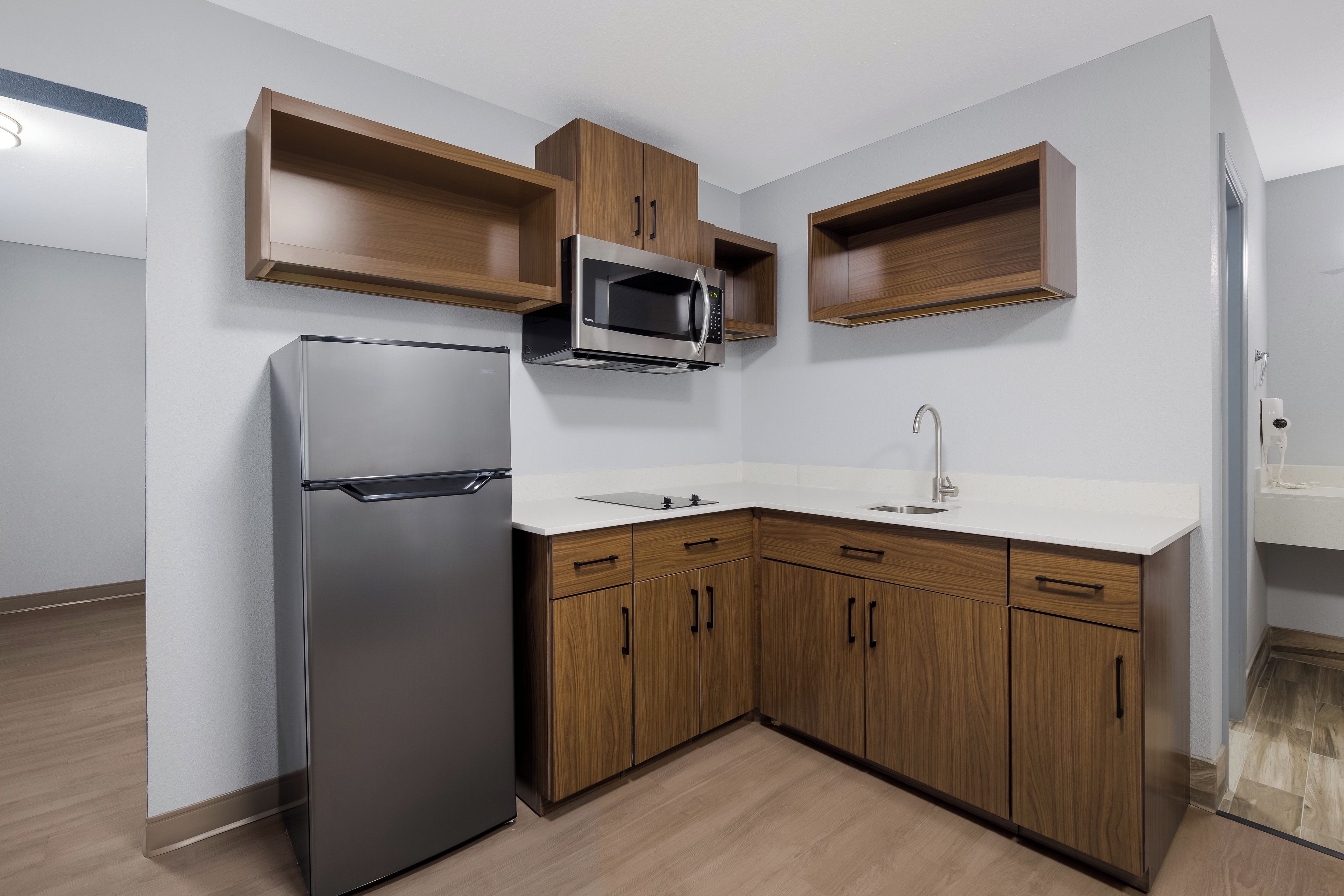 A modern kitchen with a built-in refrigerator, microwave, and sink.