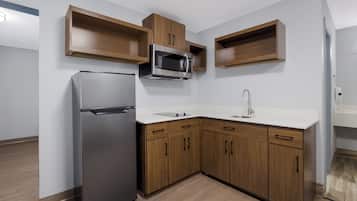 A modern kitchen with a built-in refrigerator, microwave, and sink.