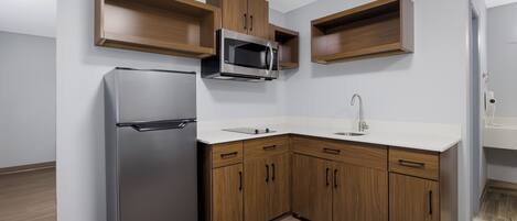 Una cocina moderna con refrigerador, microondas y pileta.