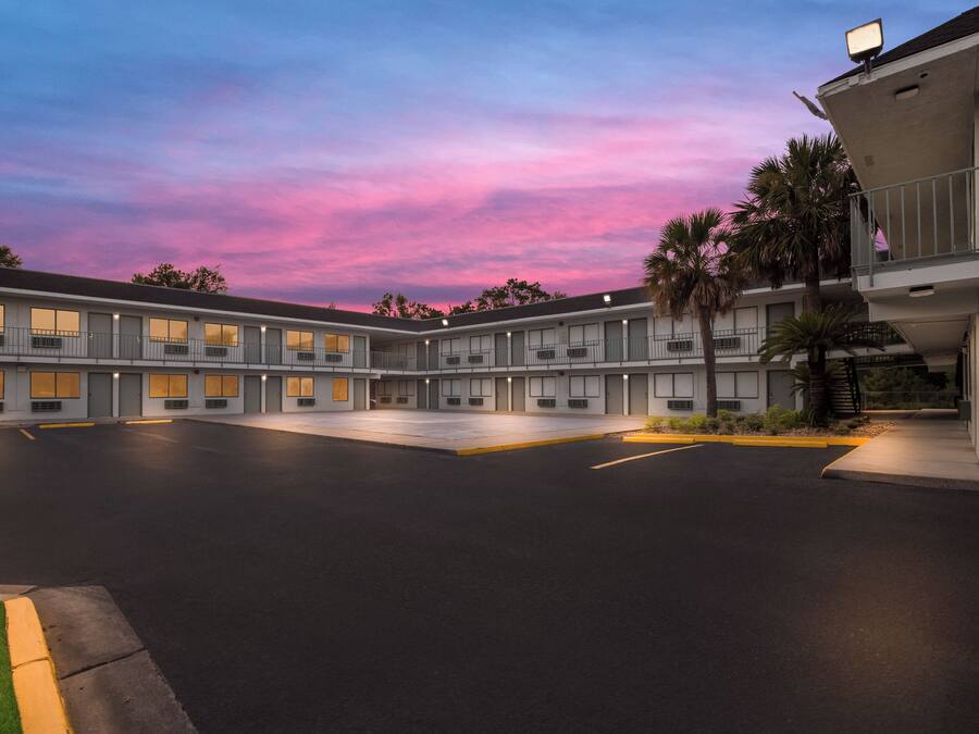 A motel with a central courtyard, multiple rooms, and a parking area.