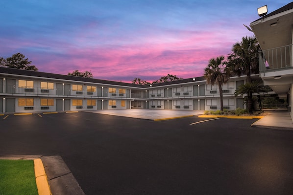 A motel with a central courtyard, multiple rooms, and a parking area.