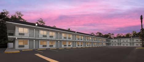 Un motel doté de nombreuses chambres, d’un parking et offrant une vue sur un ciel dégagé.