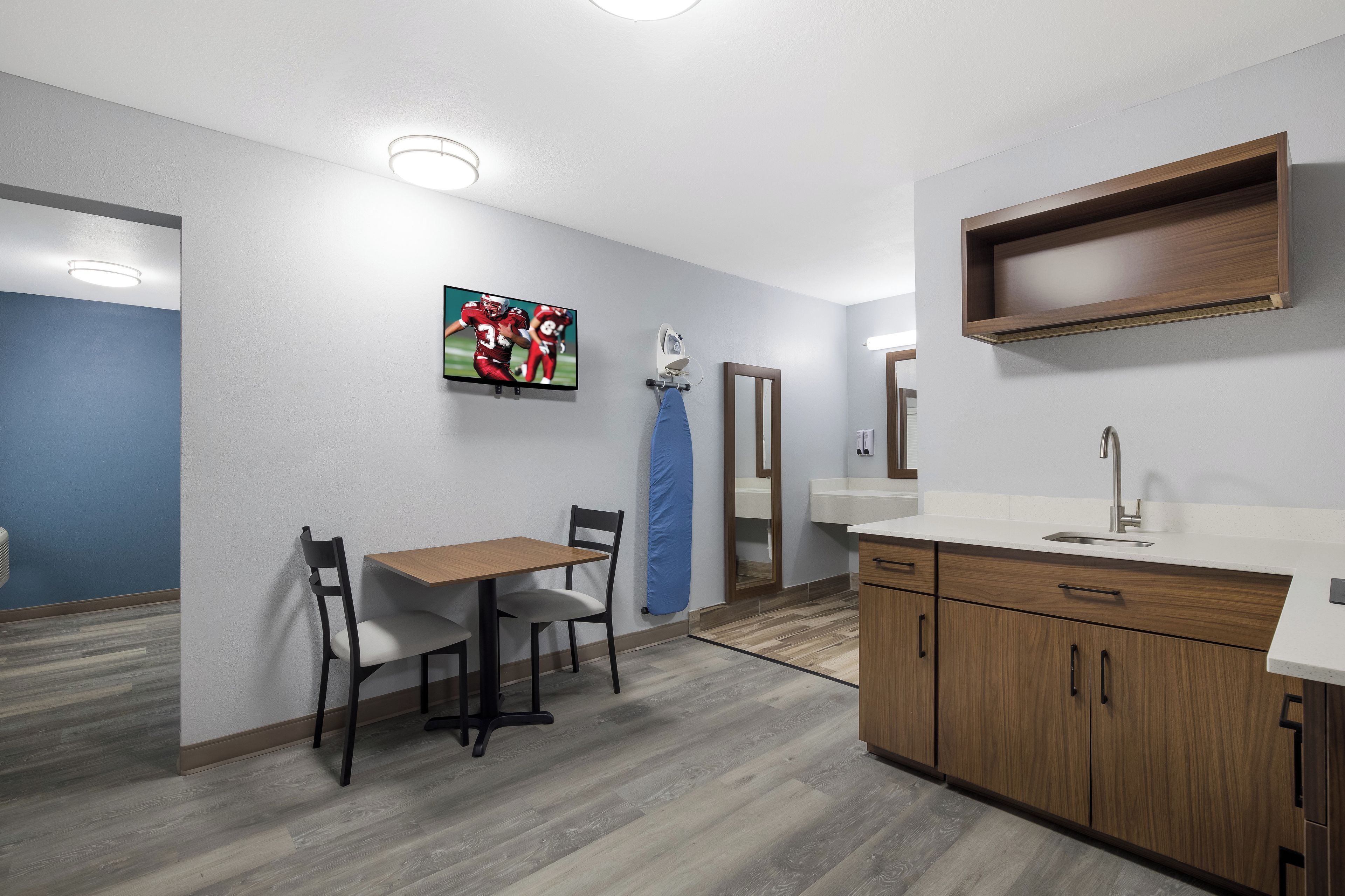 A modern kitchen with wooden cabinets, a white countertop, and a built-in oven.