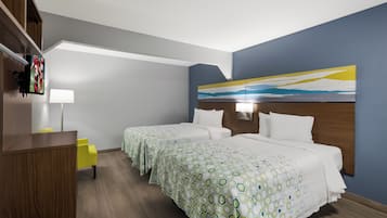 A hotel room with two beds, a desk, a chair, a painting on the wall, and a TV mounted on the wall.