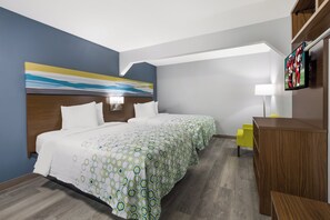 A hotel room with a bed, bedside tables, a desk, a chair, and a television.