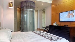 A hotel room with a bed, a desk, a television, and a glass elevator. - Xihai Ecological Garden Vacation Hotel Liu’an (Lu'an)