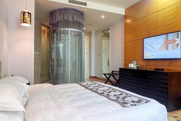 A hotel room with a bed, a desk, a television, and a glass elevator. - Xihai Ecological Garden Vacation Hotel Liu’an (Lu'an)