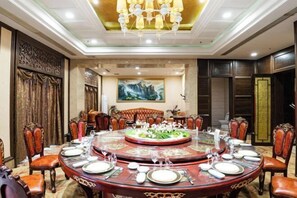 A formal dining room with a round table set for a meal, surrounded by ornate chairs. - Xihai Ecological Garden Vacation Hotel Liu’an (Lu'an)