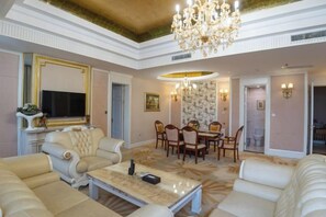 Un ampio soggiorno con un lampadario, una televisione e un'area pranzo.