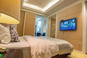 A hotel room with a bed, a television mounted on the wall, and a door leading to another room. - Xihai Ecological Garden Vacation Hotel Liu’an (Lu'an)