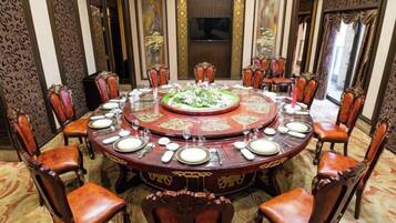 Una mesa redonda de comedor con sillas, rodeada de paneles ornamentales en la pared y un espejo grande.