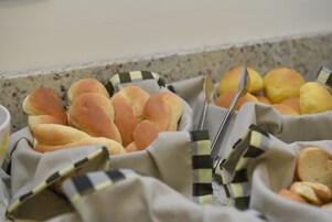 Un bufé con diferentes tipos de pan y bollos.