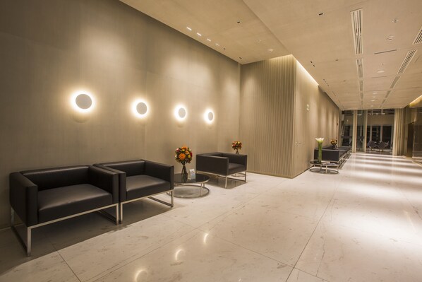 A modern waiting area with a sofa, chairs, and a coffee table.