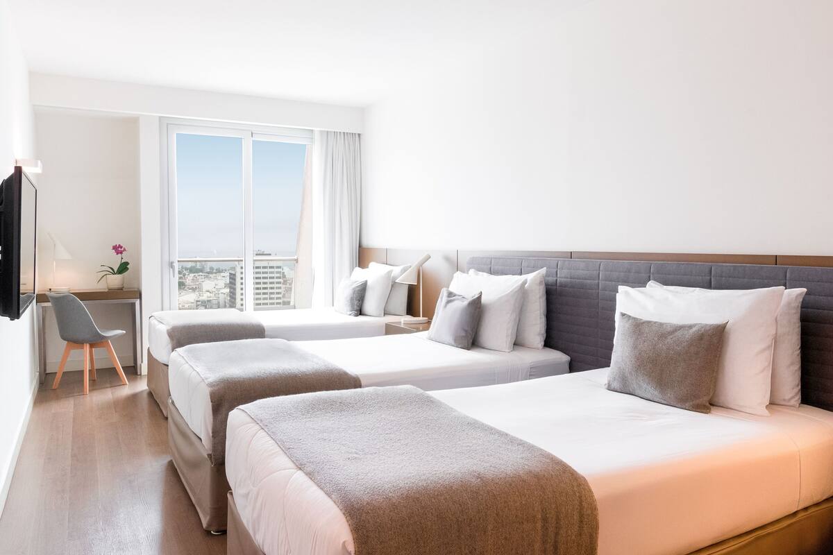 Ein Hotelzimmer mit zwei Betten, einem Schreibtisch und einem Stuhl.