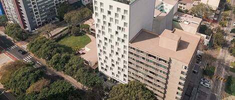 Un hotel moderno de altura con varios pisos, techo plano y un patio central.