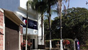 Un edificio con un letrero que dice 'DESDELLO TOURISTIC PARTIDOR DEL SOL', una entrada con reja y plantas en macetas.
