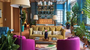 Amplia sala de estar con un sofá grande, una mesa de centro y sillones coloridos.