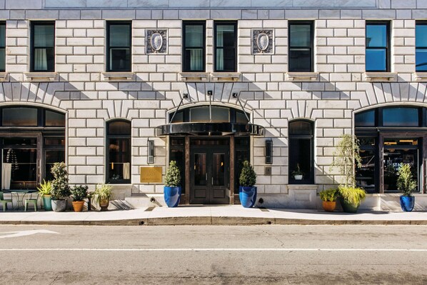 A building with a symmetrical facade, large windows, and a central entrance with a black canopy.
