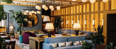 Una sala de estar moderna con un sofá azul, techo de madera y varias lámparas.
