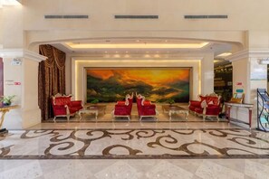 A lobby with a large painting, red seating, and a patterned floor. - Nanshan Xingmao Hotel & Resort (Lu'an)