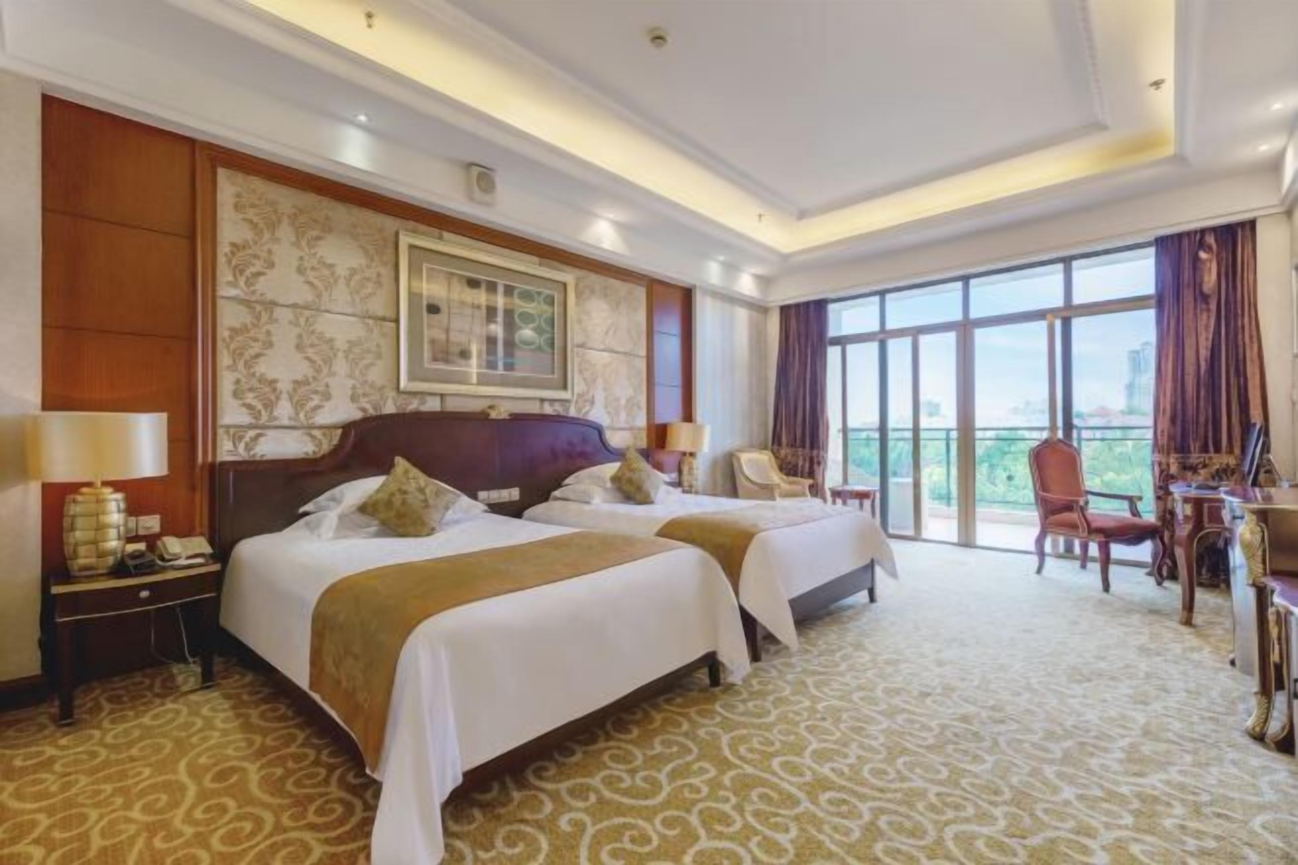 Una habitación de hotel con dos camas, un ventanal grande y un balcón.