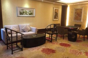 Una habitación con sofá, sillas, una mesa de centro, billar y alfombra estampada.