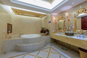 Un baño lujoso con una bañera independiente, un espejo grande y una pared decorada con azulejos.