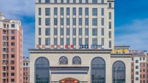Un immeuble d’hôtel à plusieurs étages, doté de grandes fenêtres et d’une enseigne bien visible au sommet.