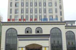 Un edificio de varios pisos con una hilera de ventanas en el nivel superior y una sección inferior con ventanas de arco.