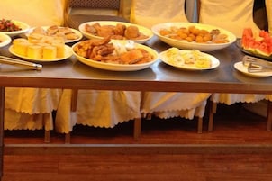 Una mesa con diversos alimentos, probablemente para un bufé o comida compartida.