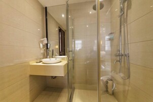 A modern bathroom with a glass-enclosed shower, a sink with a mirror, and a toilet.