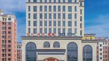 A multi-story building with a large central entrance, arched windows, and a sign with Chinese characters.