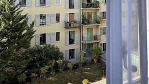 Un edificio de varios pisos con balcones, cielo despejado y vistas del entorno.