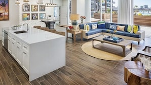 Un salon moderne doté d’un grand îlot central, d’un ensemble de canapés et d’un coin repas.