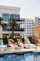 Una piscina al aire libre, camas de piscina con cargo, sombrillas