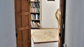 A wooden door leading to a staircase with a tiled floor.