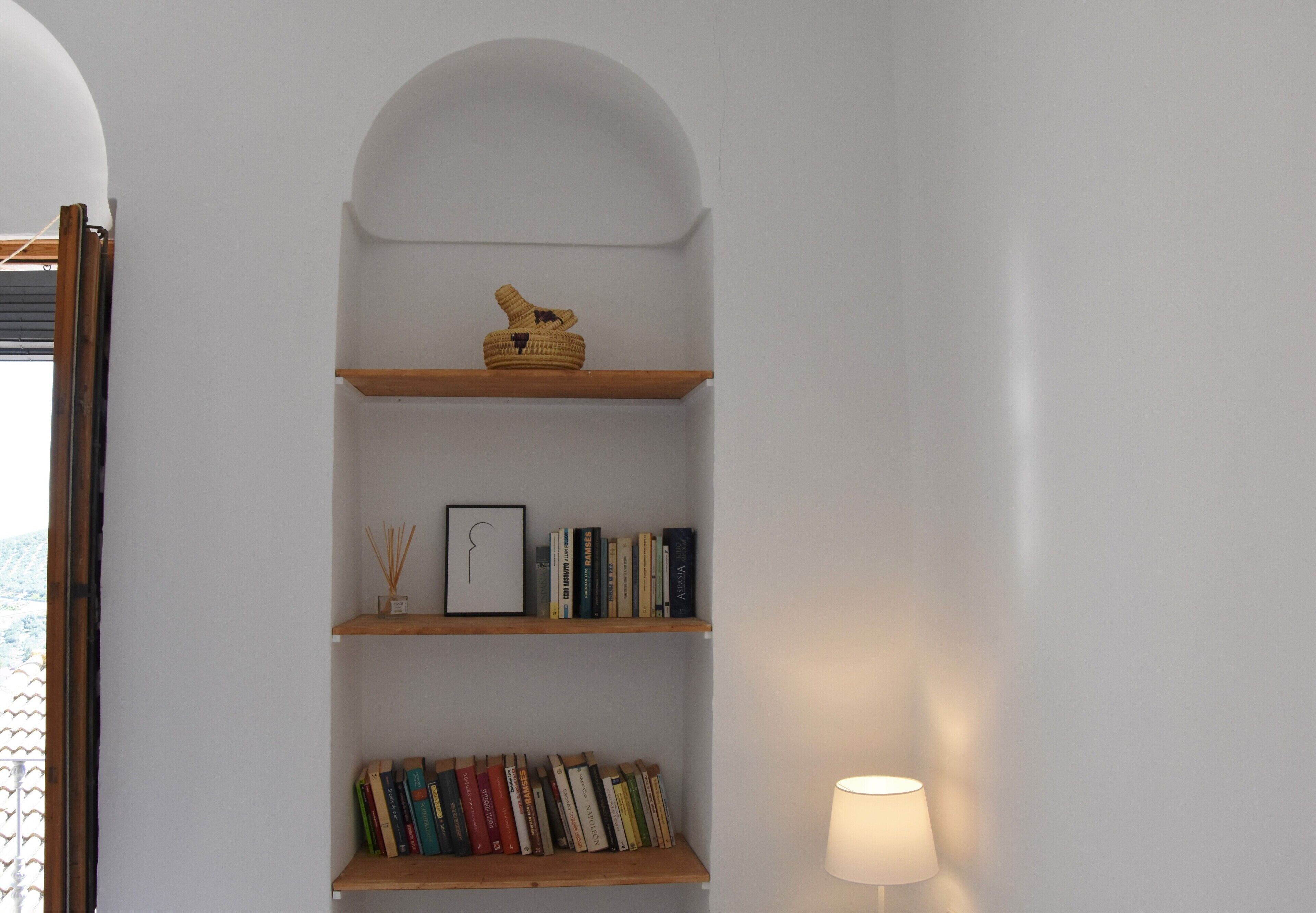 Una estantería con libros y objetos decorativos.