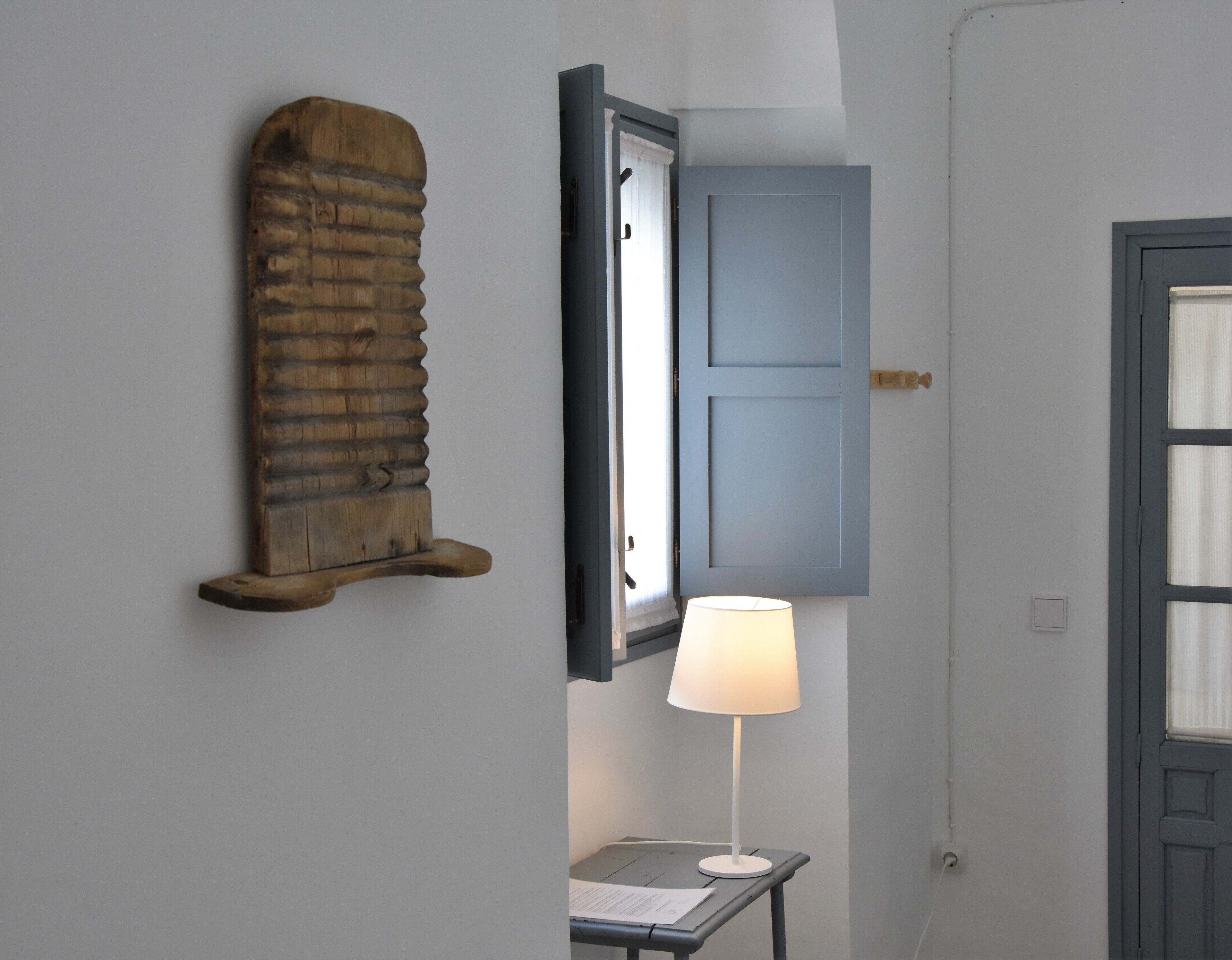 Une pièce avec un décor mural en bois, un tableau encadré, une lampe sur une table et une porte.