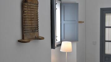 Une pièce avec un décor mural en bois, un tableau encadré, une lampe sur une table et une porte.