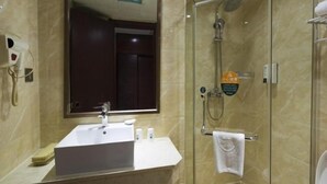 A bathroom with a glass-enclosed shower, a sink with a mirror, and a towel rack. - Greentree INN Jiangxi Yingtan Station Square (Yingtan)