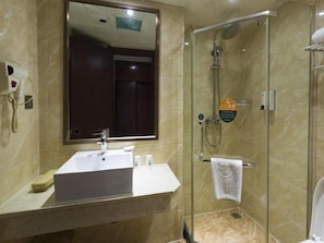 Bany amb dutxa tancada per vidre, un lavabo amb mirall i un suport per a tovalloles.