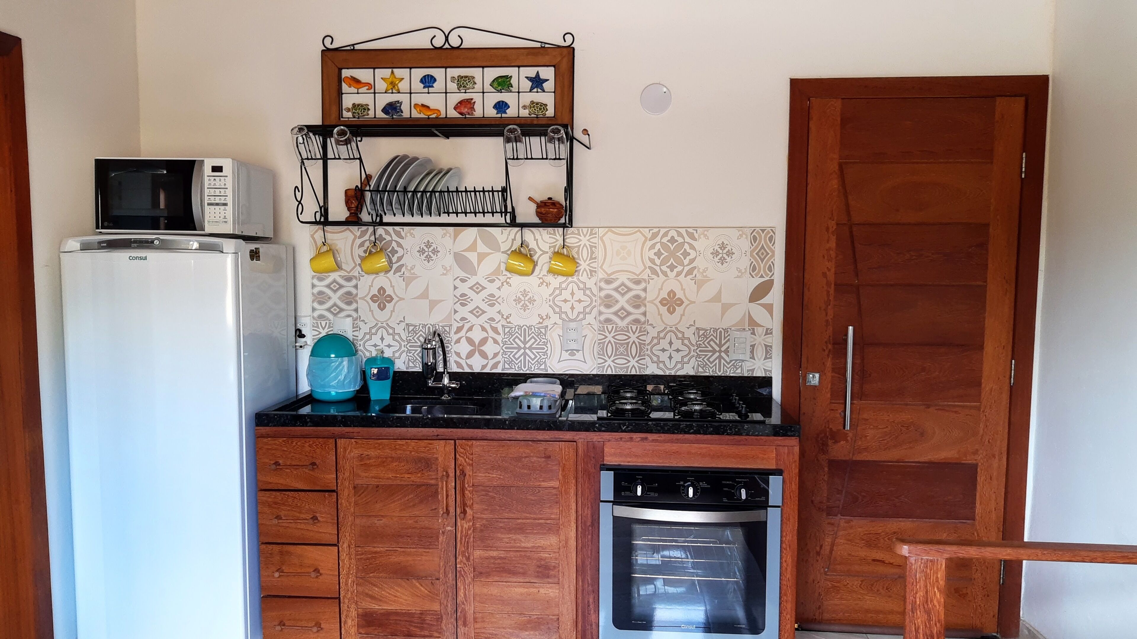 Una cocina compacta equipada con refrigerador, microondas, estufa y lavavajillas.