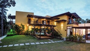 A two-story house with a balcony, a hammock, and a well-maintained lawn. - Conchas do Mar Residence (Itacaré)