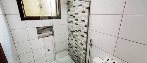 A modern bathroom with a glass-enclosed shower, a toilet, and a sink.
